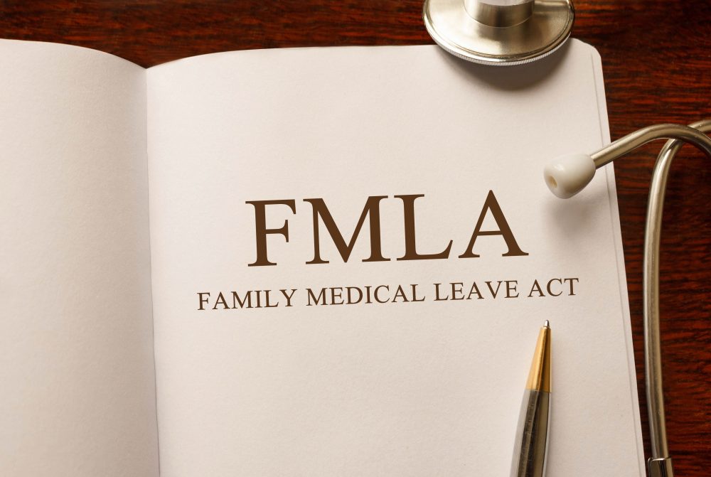 Page with FMLA (Family Medical Leave Act) on the table with stethoscope, medical concept