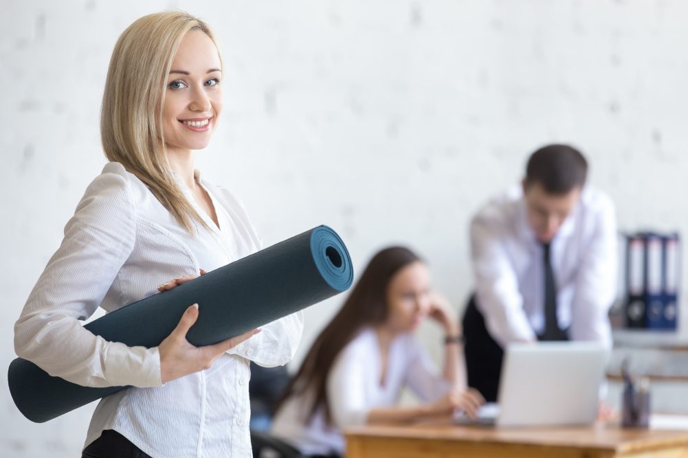 Business woman posing with exercise mat